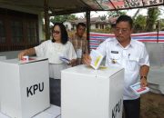 Nyoblos di TPS 14, Bupati Rupinus dan Istri Juga Kompak Berbaju Putih