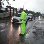 Meski Diguyur Hujan, Personil Satlantas Polres Takalar Tetap Atur Lalin